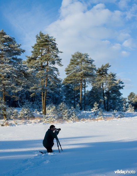 Fotograaf in besneeuwd landschap