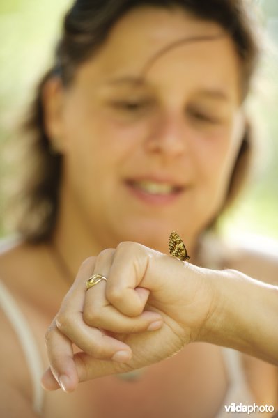 Vrouw met vlinder op hand